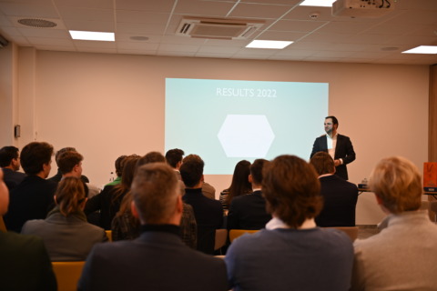 Groep collega's in vergaderzaal tijdens een seminarie bij Nestia Hospitality Group waarbij een spreker de groep toespreekt