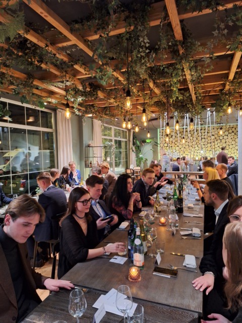 Groep collega's die samen genieten van een maaltijd aan tafel tijdens een residentieel seminarie bij Nestia Hospitality Group