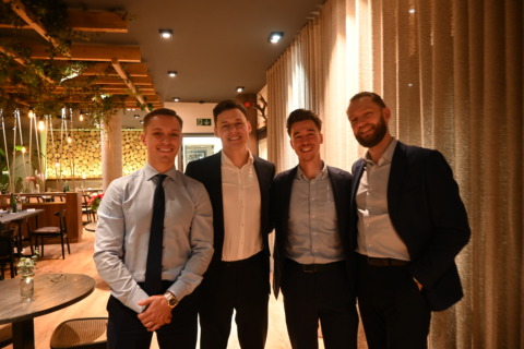 Lachende groep collega's samen voor een maaltijd tijdens een residentieel seminarie bij Nestia Hospitality Group