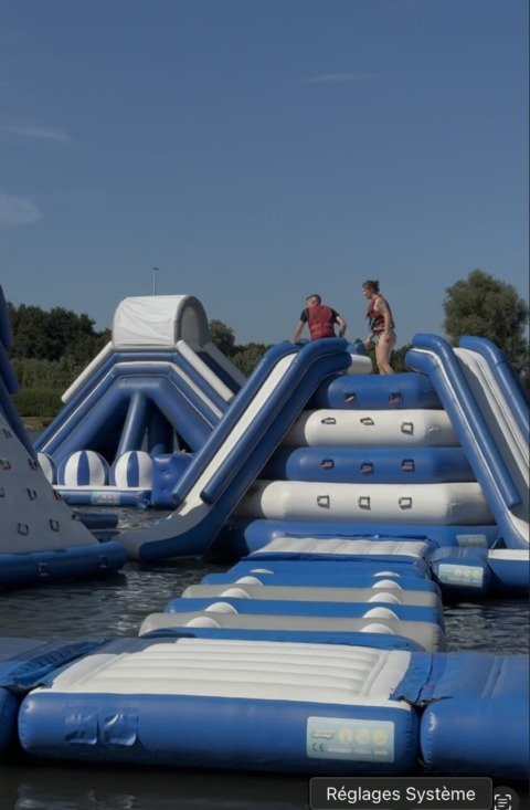 Twee deelnemers op een opblaasbaar waterattractie tijdens een teambuilding bij Ibis Budget Brugge Jabbeke