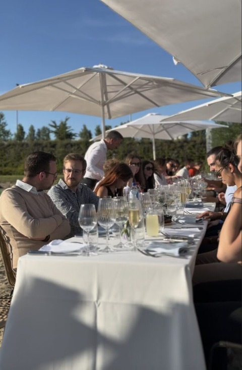 Groep aan tafel buiten in de zon tijdens een teambuilding bij Ibis Budget Brugge Jabbeke