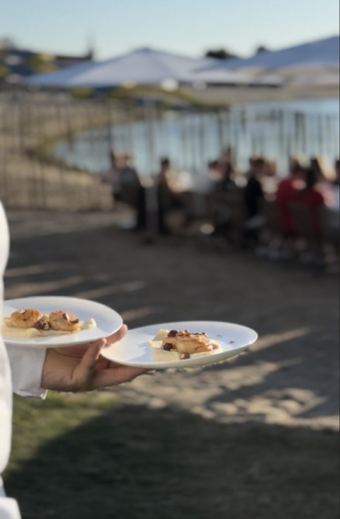 Ober serveert gerechten tijdens een buitenevenement bij Ibis Budget Brugge Jabbeke
