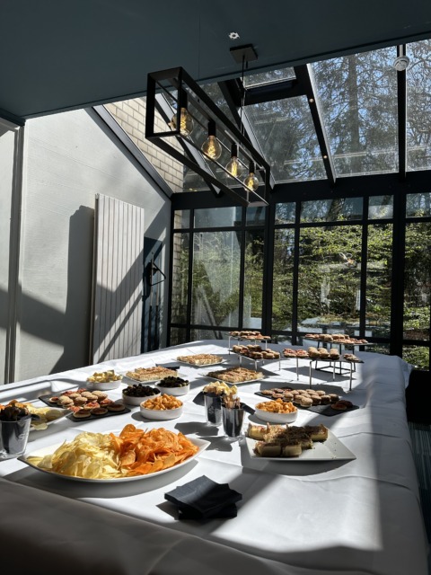 Gedekte tafel met chips, noten en andere snacks tijdens een dagpauze van een seminarie bij Nestia Hospitality Group