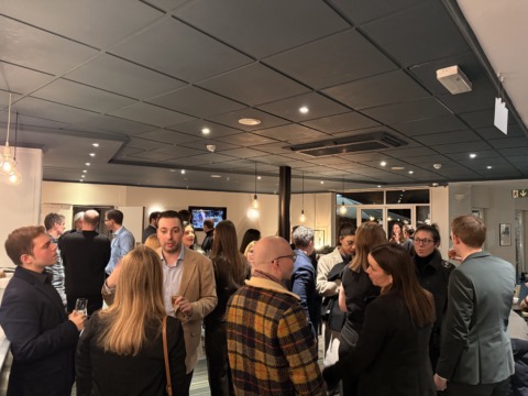 Img Professionals talk over drinks during a lively indoor networking reception